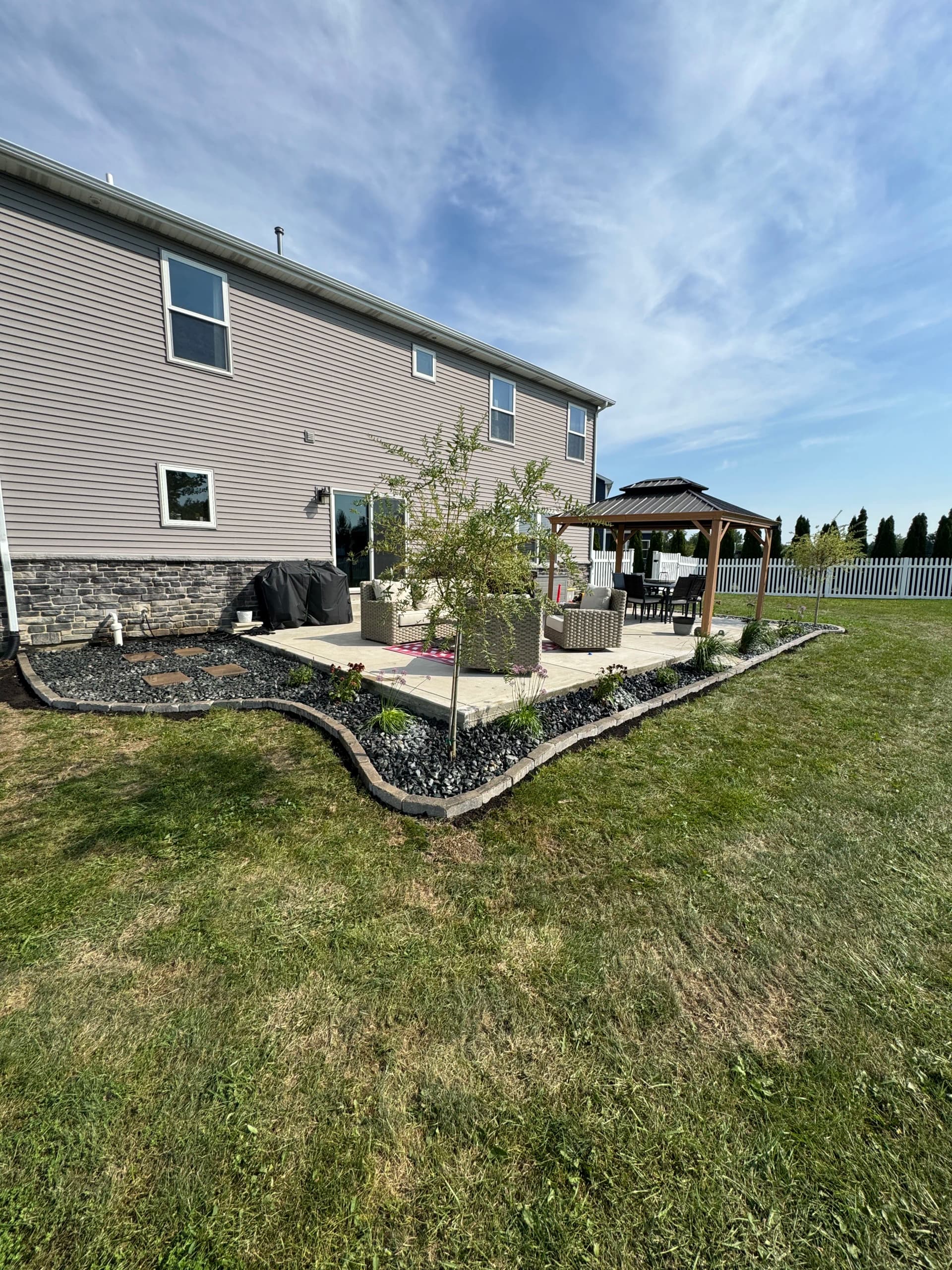 Paver Border, Rock, and New Plants Give This Backyard a Finished Look